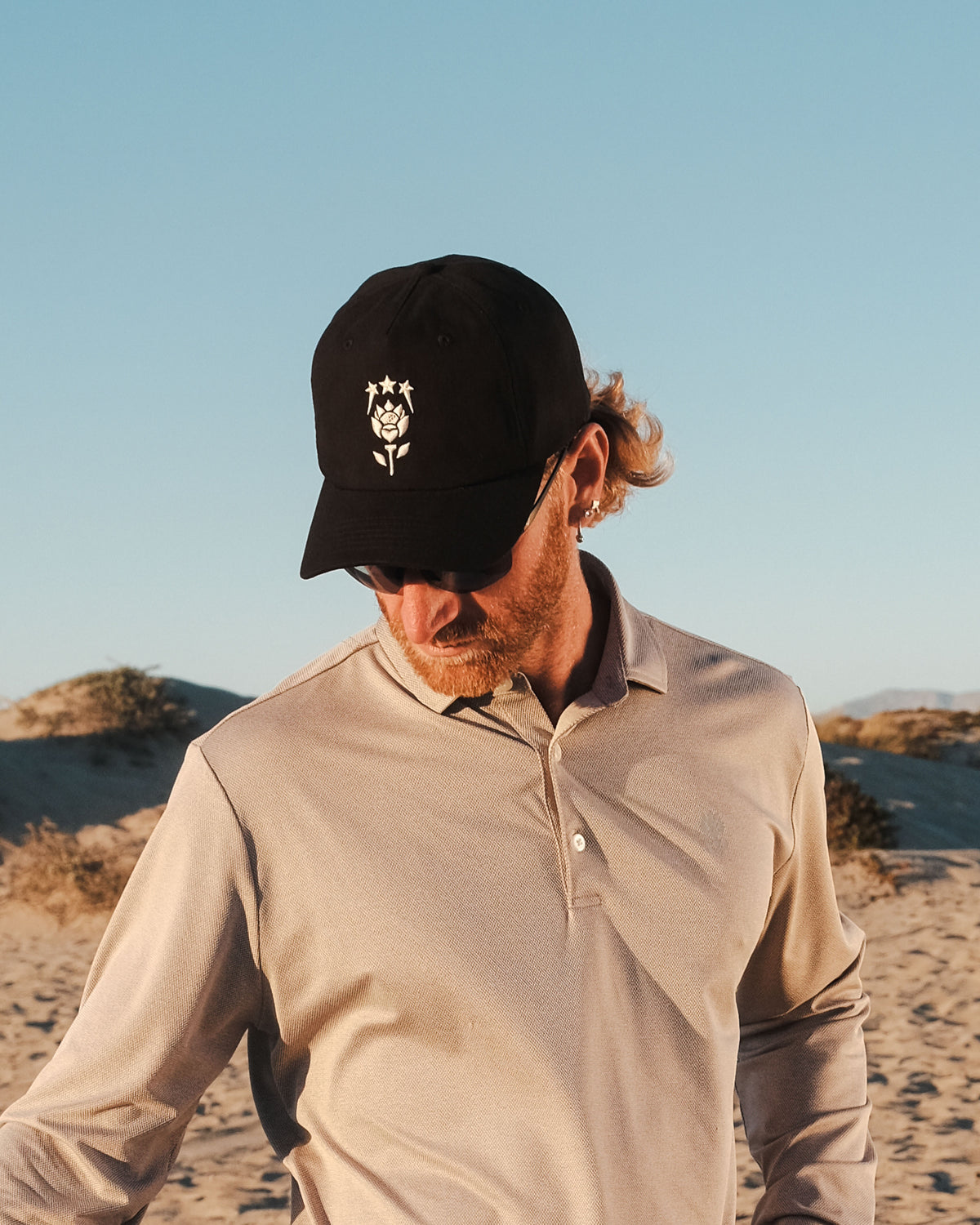 Dune Hat styled with Shores Polo — black cap and polo by Fiori Golf