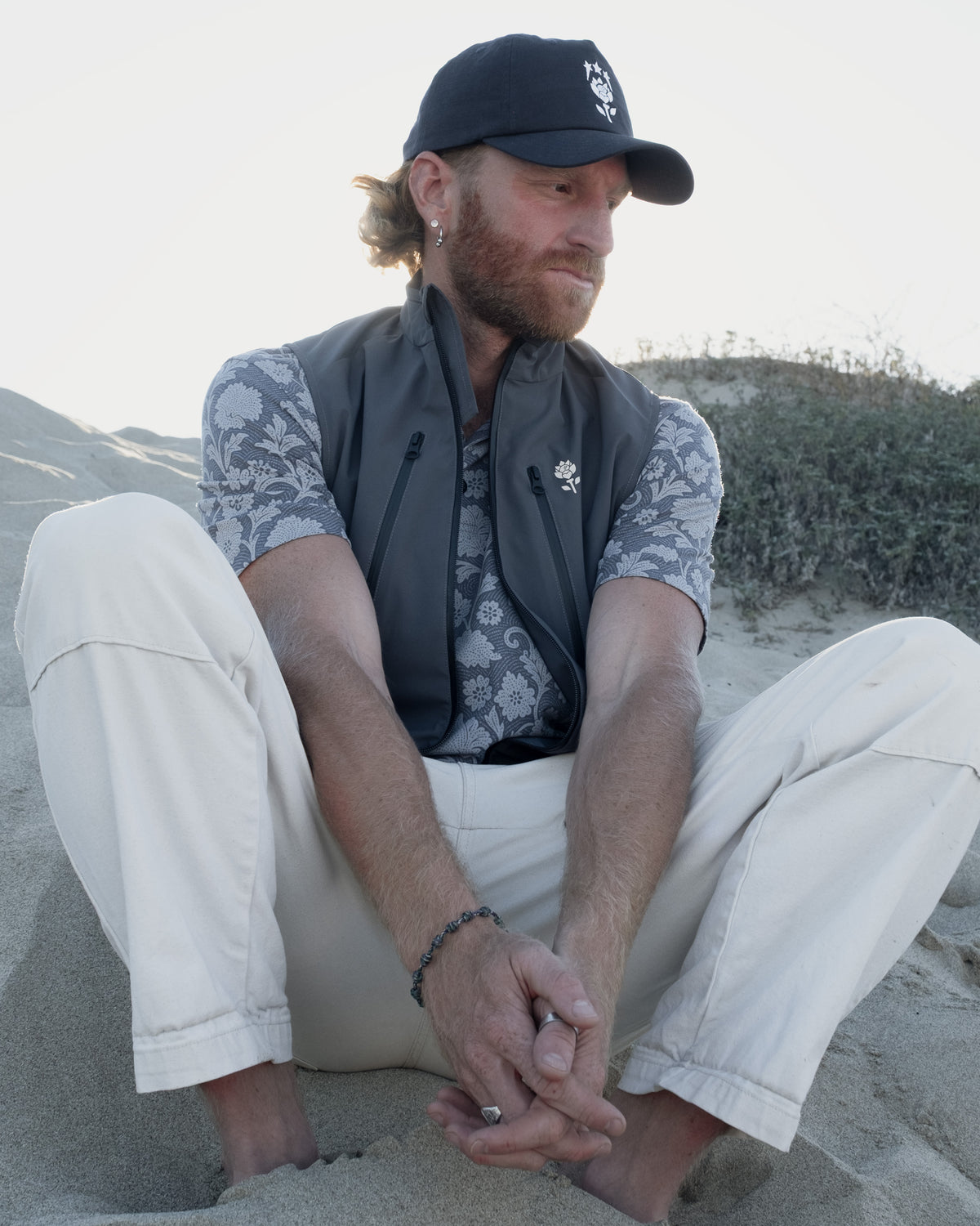 Phantom Polo Paisley lifestyle — blue polo styled with Onda Vest and Dune Hat by Fiori Golf